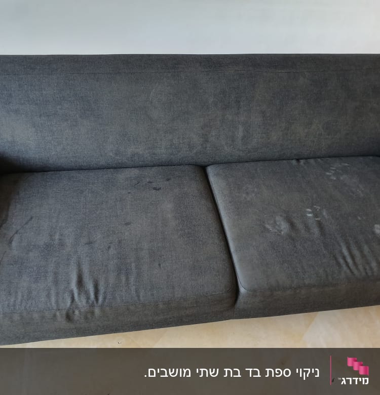 ספה כהה עם כתמים על המושב